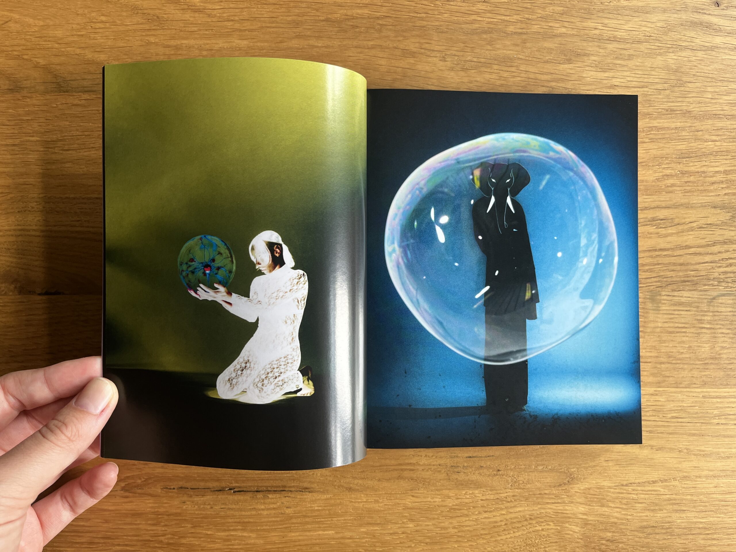 Open spread from Mixed: a figure in white holds a patterned globe beside a dark figure enclosed in a glowing blue bubble.
