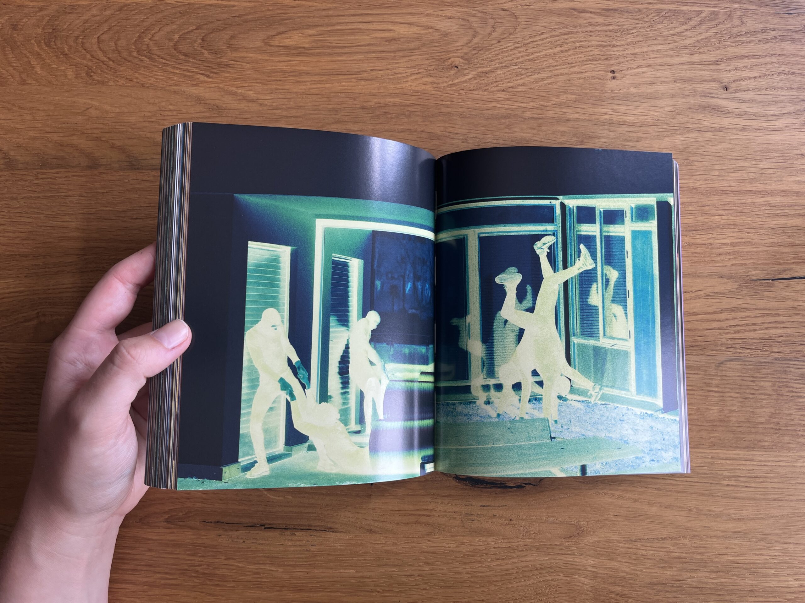 Open spread from Mixed showing an inverted-colour image of several figures moving outside a building.