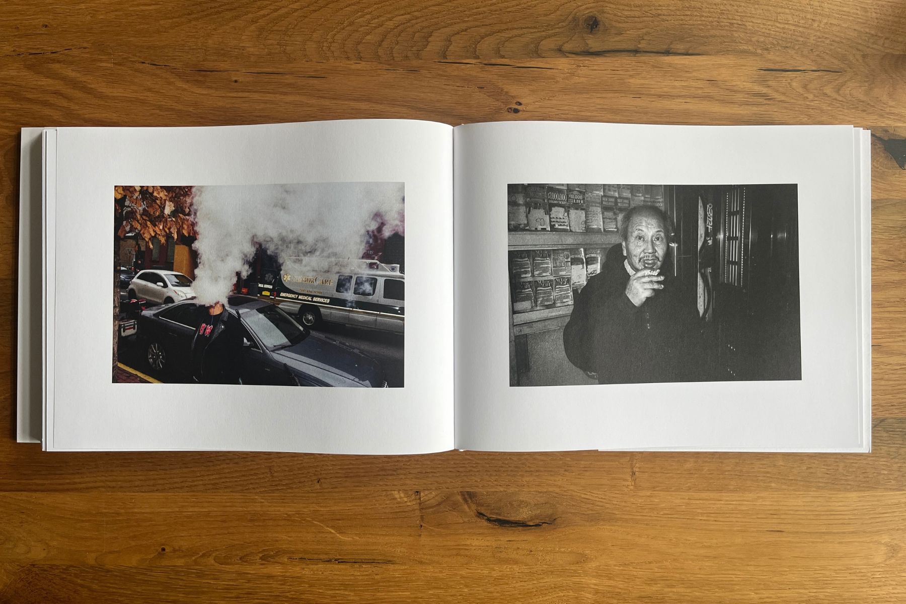Open photobook with a steaming city street scene on the left and a black-and-white portrait of an older man on the right.