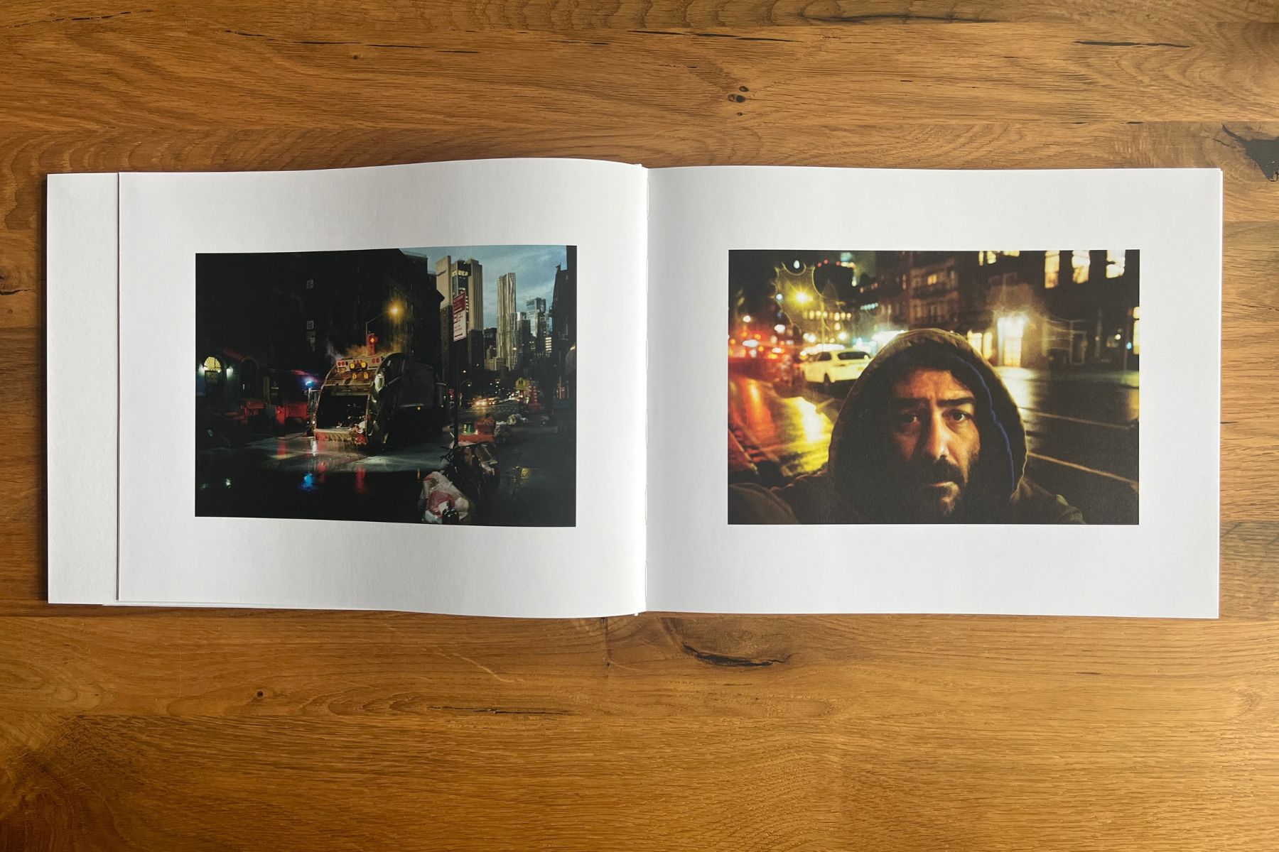 Open photobook with a rainy New York street scene on the left and a close-up portrait of a bearded man at night on the right.